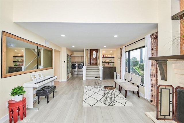 interior space featuring washing machine and dryer, recessed lighting, visible vents, stairs, and light wood finished floors