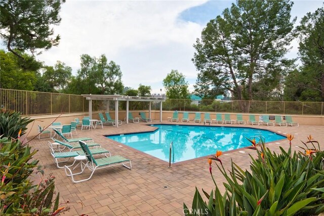 view of swimming pool with a patio and a pergola