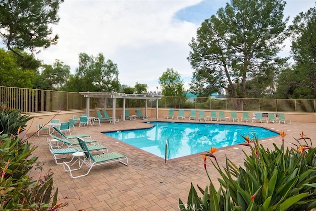 community pool with a patio, fence, and a pergola