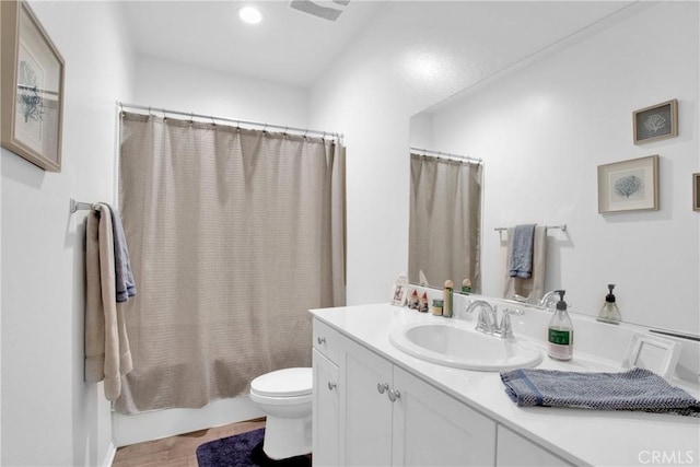 full bathroom featuring hardwood / wood-style floors, toilet, vanity, and shower / bath combo