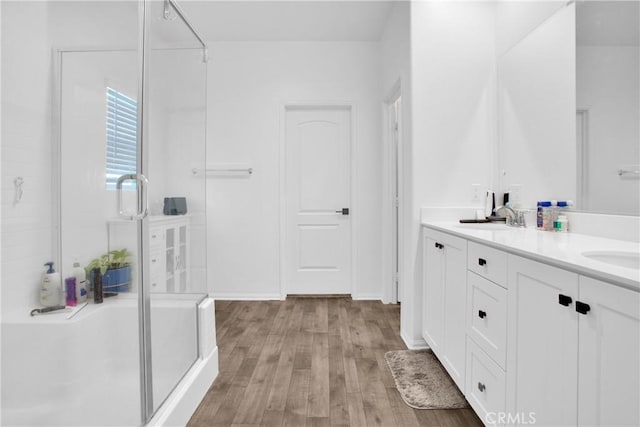 bathroom featuring a shower with shower door, hardwood / wood-style flooring, and vanity