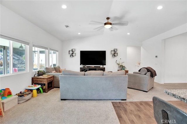 carpeted living room featuring ceiling fan and lofted ceiling