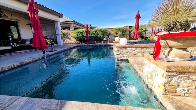 view of pool with pool water feature and a patio