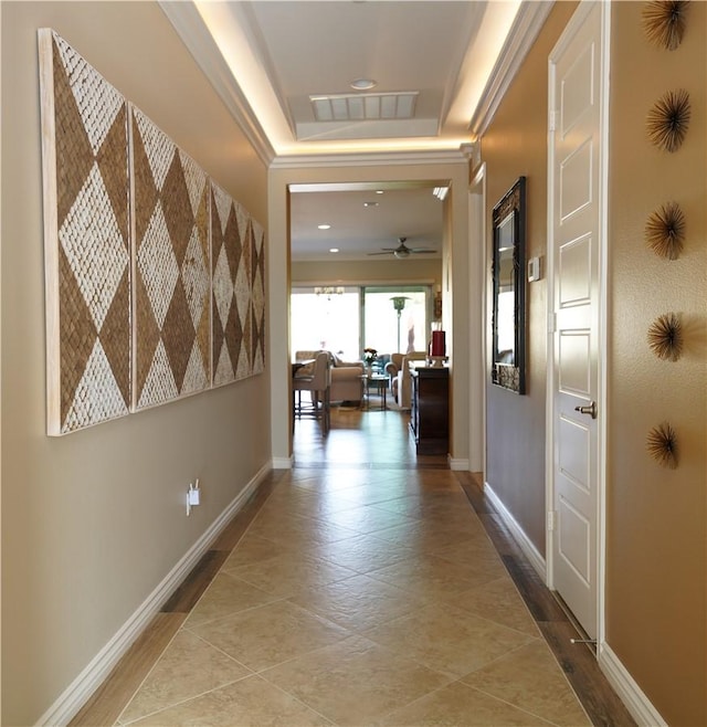 corridor with a tray ceiling and crown molding