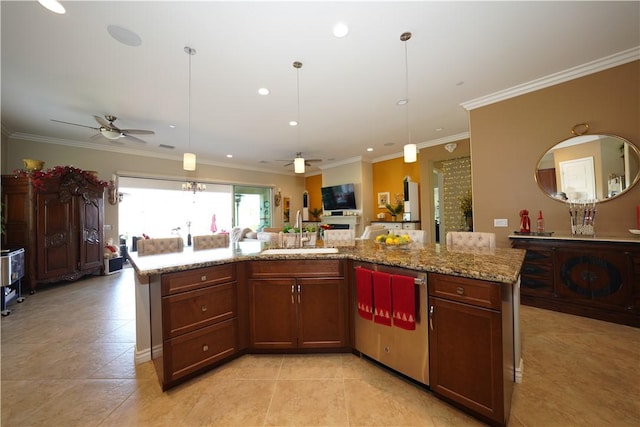 kitchen featuring a center island with sink, ceiling fan, decorative light fixtures, light stone countertops, and sink