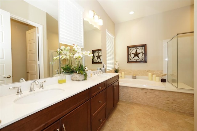 bathroom with vanity, tile patterned flooring, and a relaxing tiled tub