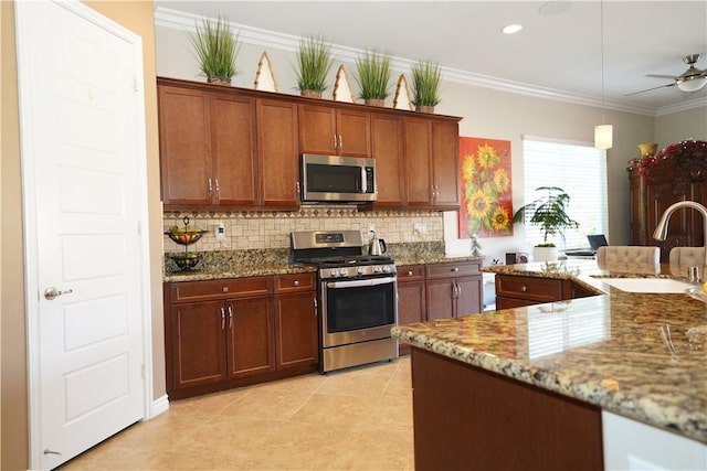 kitchen featuring stone counters, appliances with stainless steel finishes, ornamental molding, and sink