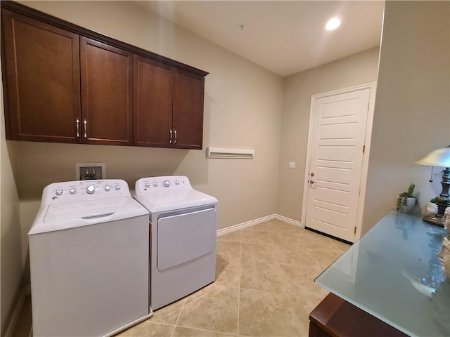 laundry room featuring washer and clothes dryer, light tile patterned floors, and cabinets