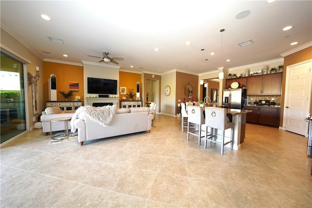 living room featuring light tile patterned flooring, ceiling fan, and ornamental molding