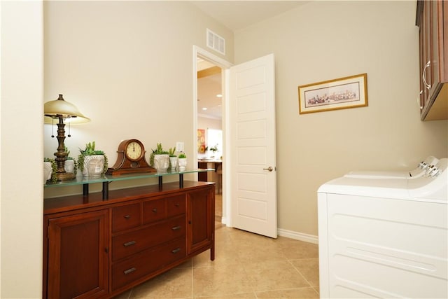 laundry room with light tile patterned floors, independent washer and dryer, and cabinets