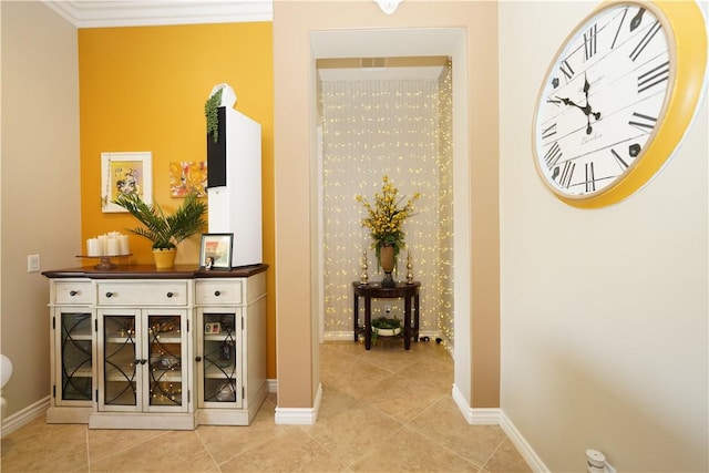 hallway with ornamental molding and light tile patterned flooring