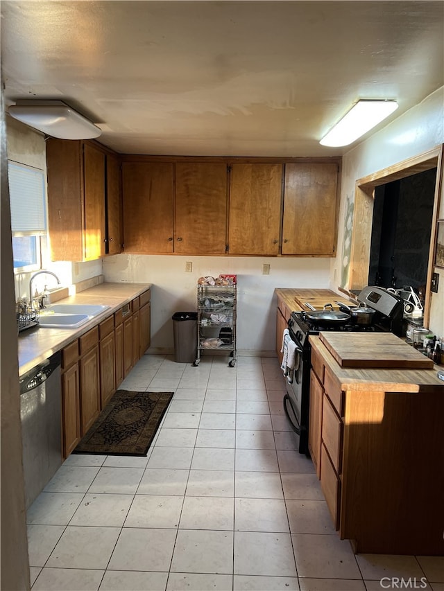 kitchen featuring light tile patterned floors, appliances with stainless steel finishes, and sink