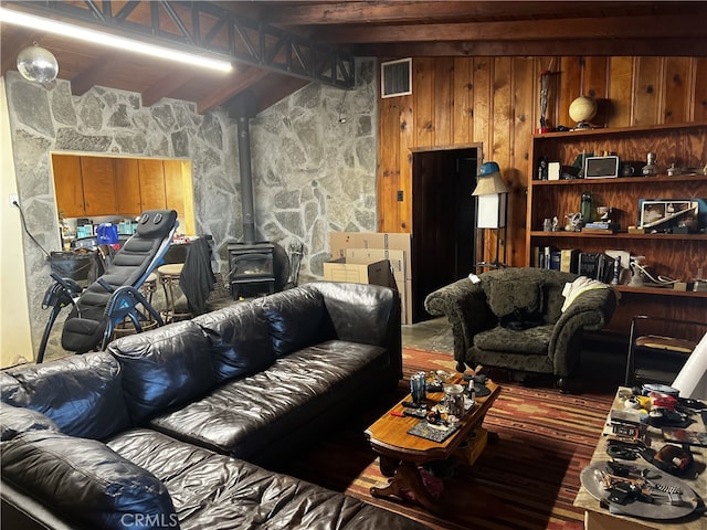 living room with beam ceiling and a wood stove