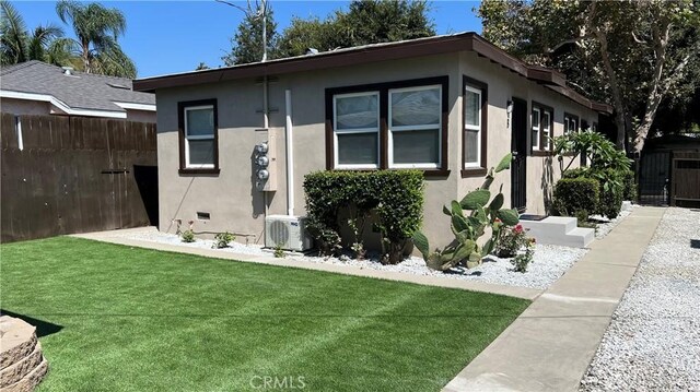 view of front of house with a front yard and ac unit