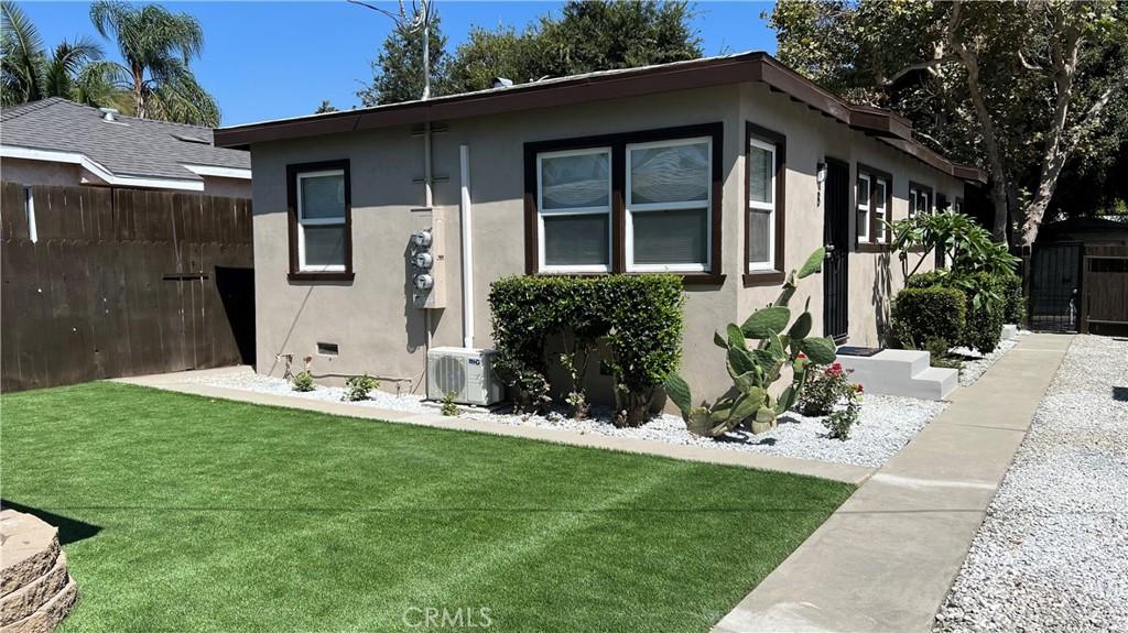 view of front of property featuring a front lawn and ac unit