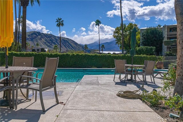 view of swimming pool with a patio area and a mountain view