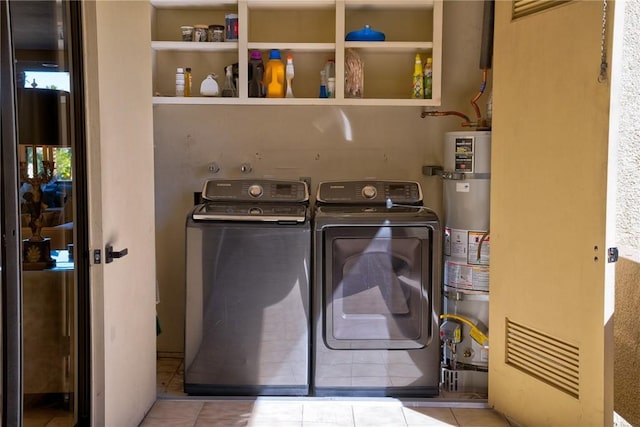 clothes washing area with secured water heater, independent washer and dryer, and light tile patterned flooring