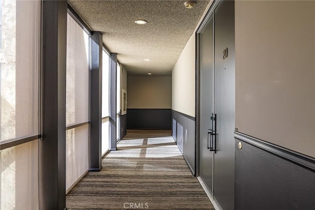 hallway featuring expansive windows and a textured ceiling