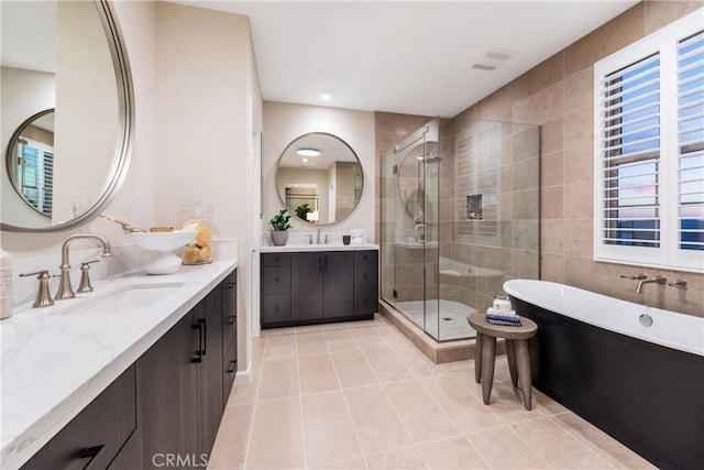 bathroom featuring tile patterned floors, vanity, and shower with separate bathtub