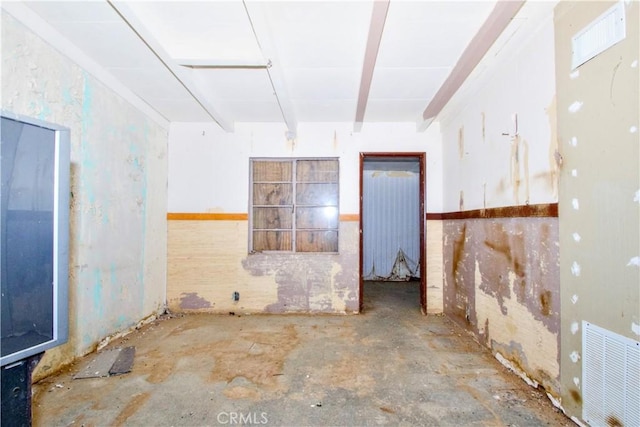 unfurnished room featuring beamed ceiling