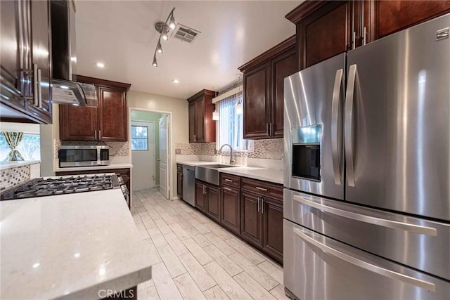 kitchen featuring stainless steel appliances, dark brown cabinets, and sink