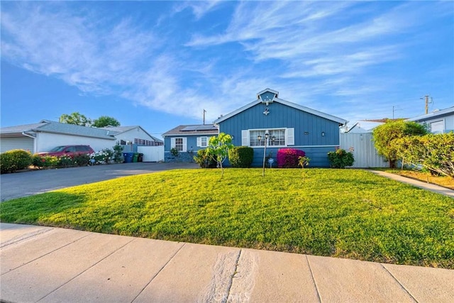 ranch-style house with a front lawn and solar panels