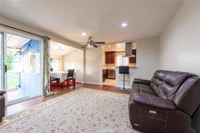 living room with vaulted ceiling, ceiling fan, and wood-type flooring