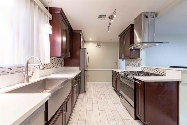 kitchen featuring backsplash, sink, hanging light fixtures, stainless steel appliances, and ventilation hood