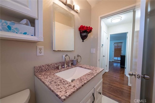 bathroom featuring toilet, vanity, and hardwood / wood-style flooring