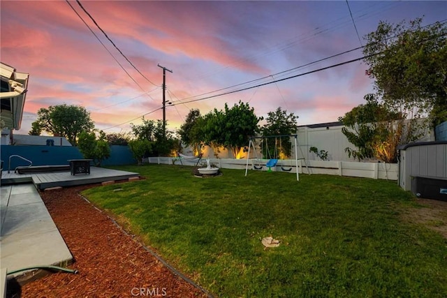 yard at dusk featuring a deck