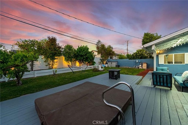 deck at dusk with a yard and a fire pit