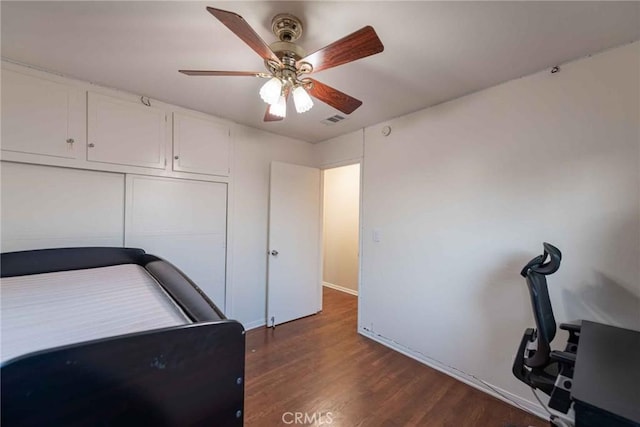 bedroom featuring ceiling fan, dark wood-type flooring, and a closet