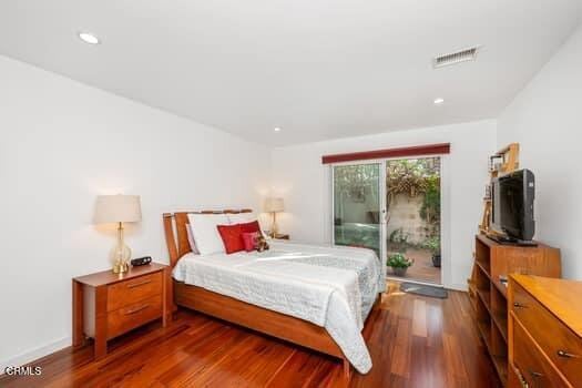 bedroom with dark hardwood / wood-style flooring