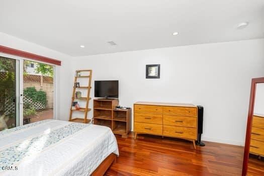 bedroom with dark hardwood / wood-style floors and access to outside