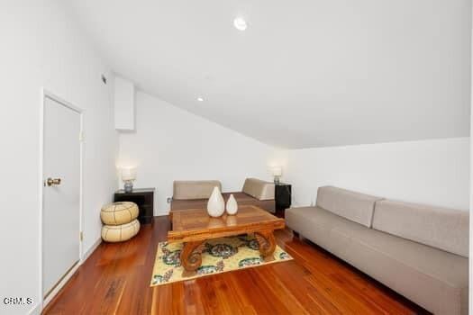 living room with vaulted ceiling and wood-type flooring