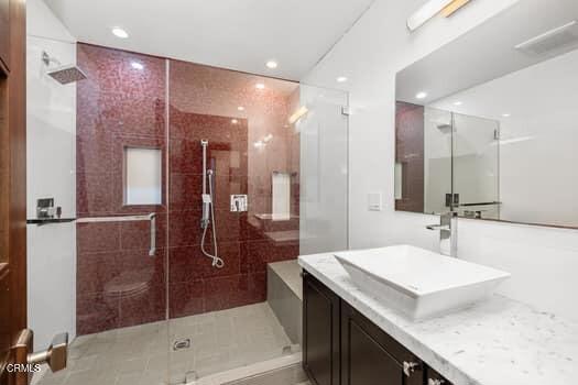 bathroom featuring vanity and a shower with door