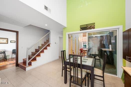 dining room with light tile patterned floors and a towering ceiling