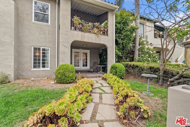 exterior space with a balcony and french doors