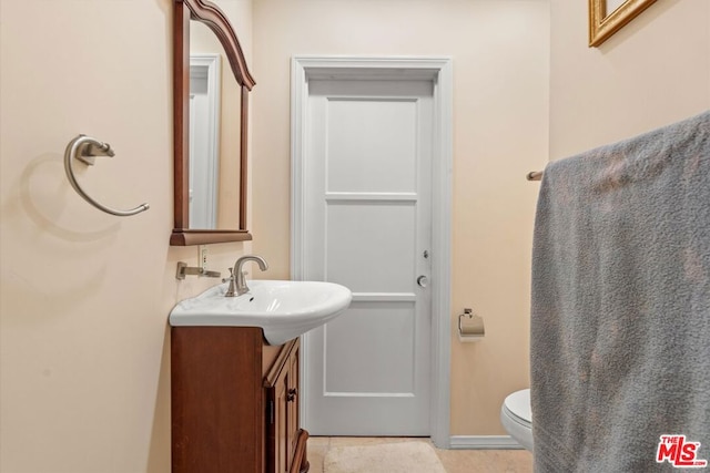 bathroom featuring tile patterned floors, vanity, and toilet