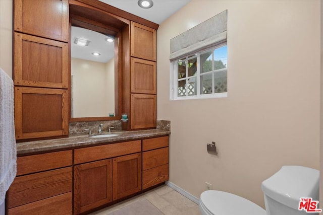 bathroom with tile patterned flooring, vanity, and toilet