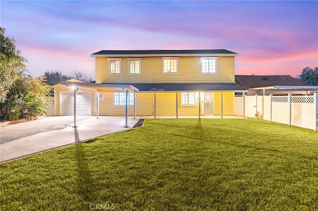 back house at dusk with a garage and a yard