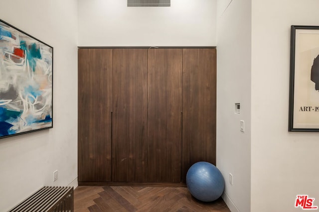 exercise room featuring dark parquet flooring