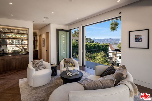 living room featuring a mountain view, dark parquet floors, and sink