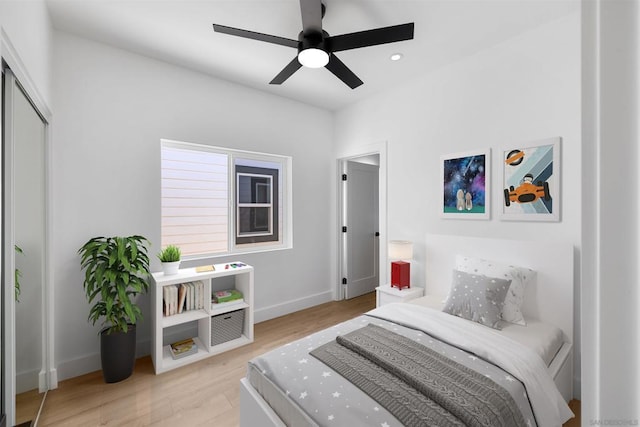 bedroom featuring ceiling fan, a closet, and light hardwood / wood-style flooring