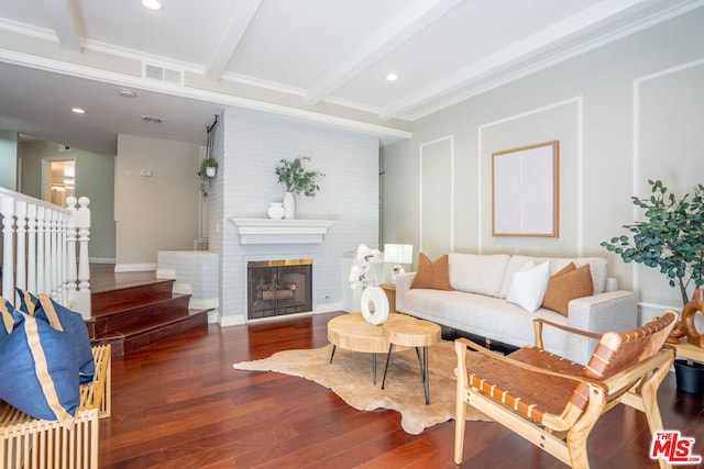 living room featuring ornamental molding, dark hardwood / wood-style flooring, beam ceiling, and a fireplace