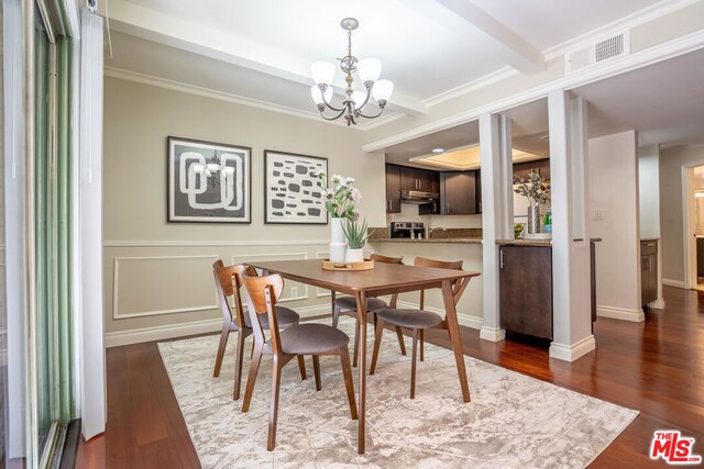 dining space with a notable chandelier, crown molding, and hardwood / wood-style flooring