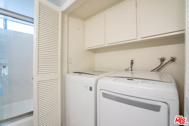 washroom with cabinets and independent washer and dryer