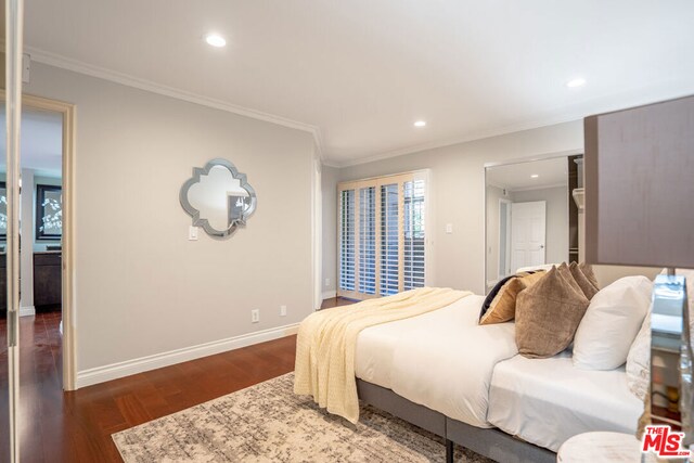 bedroom with dark wood-type flooring and crown molding