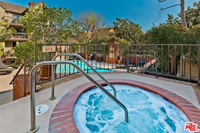 view of pool with a hot tub