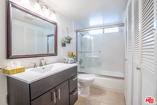 full bathroom with toilet, vanity, tile patterned flooring, and enclosed tub / shower combo